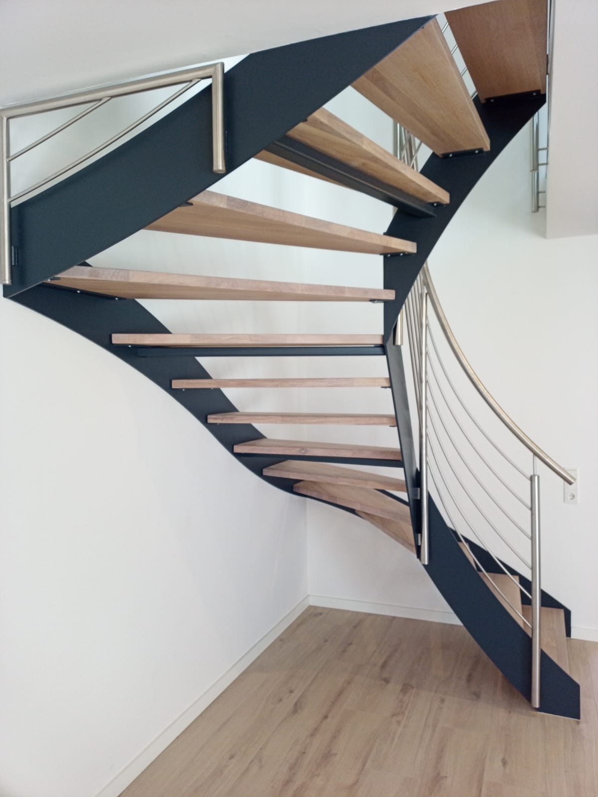 Geschwungene Innentreppe aus Holz und Stahl – AN Metallbau GmbH